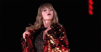 Taylor Swift In Red Sequined Jacket Holding Microphone GIF