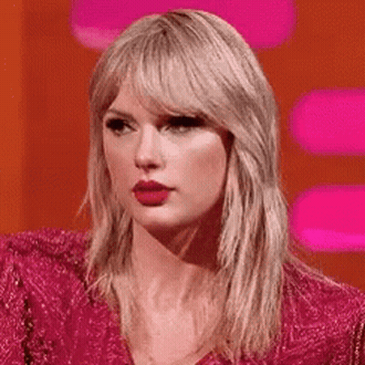 Taylor Swift Is Wearing A Pink Dress And Red Lipstick While Sitting On A Stage . GIF