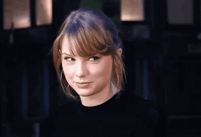 Taylor Swift Making Funny Face In Black Shirt And Hoop Earrings GIF