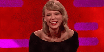 Taylor Swift Smiling In Front Of Red Background GIF