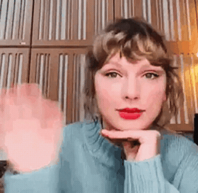 Taylor Swift Waving In Blue Sweater And Red Lipstick GIF
