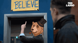Ted Lasso Bear Head Points At Believe Sign GIF