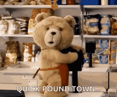 Teddy Bear In Apron Holding Black Object In Store GIF