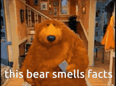 Teddy Bear In Black Shirt And White Shorts Sitting In Chair GIF