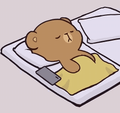 Teddy Bear Laying on Bed With Phone