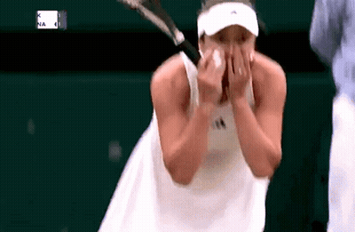 Tennis Player Wiping Face While Holding Racquet GIF
