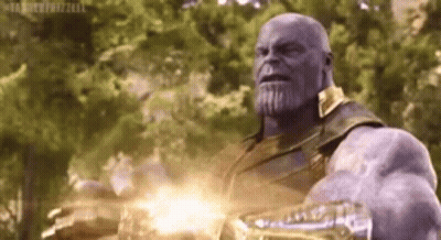 Thanos From Avengers : Infinity War Is Holding A Glowing Glove In His Hand . GIF