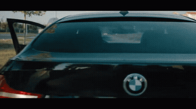 The Back Of A Black Bmw With The Door Open And A Bmw Logo GIF
