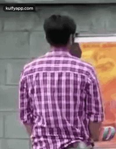 The Back Of A Man In A Plaid Shirt Is Shown . GIF