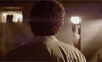 The Back Of A Man 'S Head Is Shown In A Dark Room . GIF
