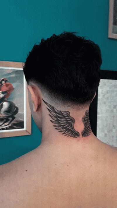 The Back Of A Man 'S Neck Has A Tattoo Of Wings On It GIF