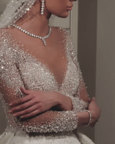 The Bride Is Wearing A Necklace And Earrings And A Veil GIF
