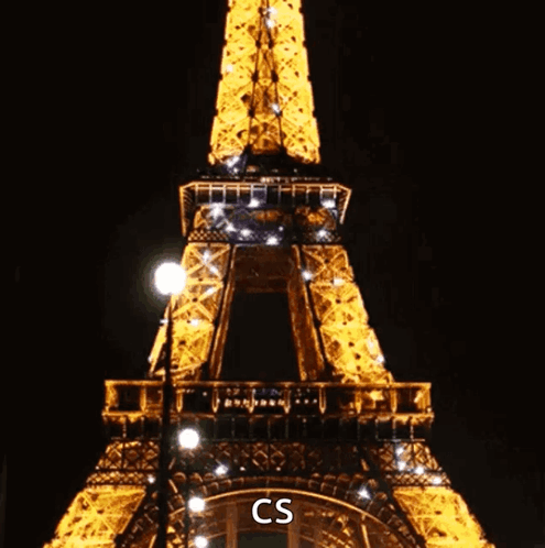 The Eiffel Tower Is Lit Up At Night And Says Cs On The Bottom Right GIF