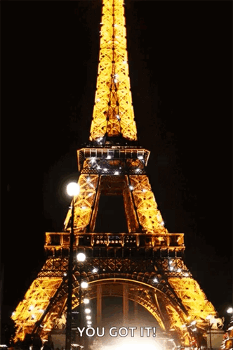 The Eiffel Tower Is Lit Up At Night And Says " You Got It " Below It GIF