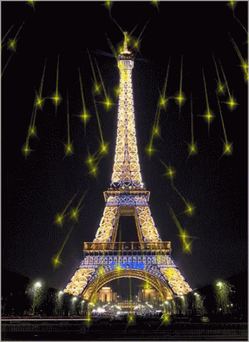 The Eiffel Tower Is Lit Up At Night And Surrounded By Sparkling Stars GIF