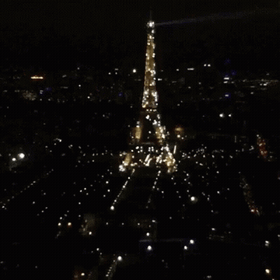 The Eiffel Tower Is Lit Up At Night GIF