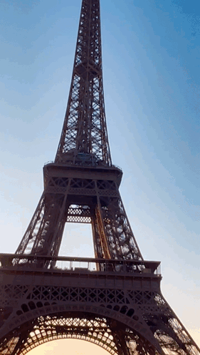 The Eiffel Tower Is Lit Up At Sunset GIF
