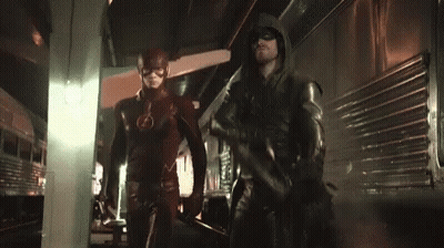 The Flash And Green Arrow Are Standing Next To Each Other In A Dark Room . GIF