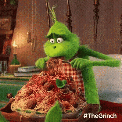 The Grinch From The Movie The Grinch Is Eating Spaghetti And Meatballs On A Plate . GIF