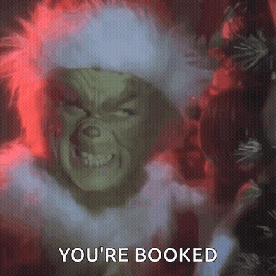 The Grinch From The Movie The Grinch Is Looking At The Camera And Saying `` You 'Re Booked '' . GIF