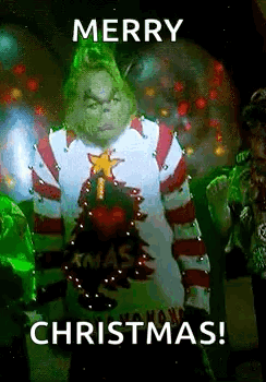 The Grinch From The Movie The Grinch Is Wearing A Christmas Sweater And Holding A Christmas Tree . GIF
