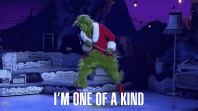 The Grinch Is Wearing A Santa Suit And Holding A Stick While Dancing On A Stage . GIF