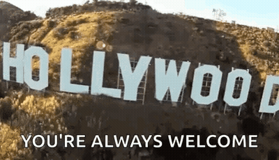 The Hollywood Sign Is Sitting On Top Of A Hill With The Words `` You 'Re Always Welcome '' Written Below It . GIF