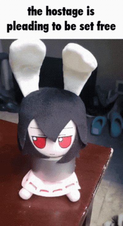 The Hostage Is Pleading To Be Set Free With A Stuffed Bunny On A Table GIF