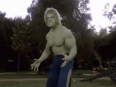The Hulk Is Standing In A Park With His Arms Outstretched . GIF