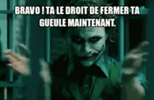 The Joker From The Movie The Dark Knight Is Standing In Front Of A Prison Cell With His Hands Outstretched . GIF