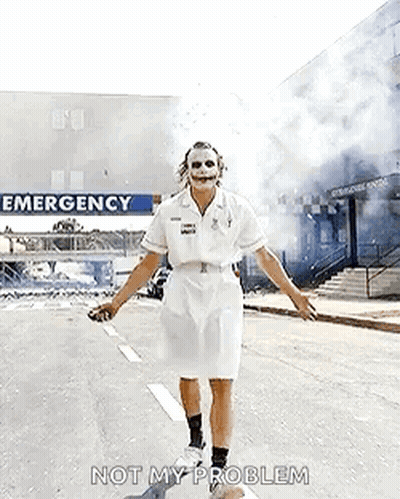 The Joker Is Dressed As A Nurse And Is Walking Down The Street . GIF