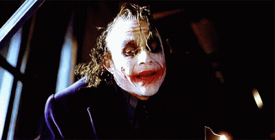 The Joker Is Wearing A Purple Jacket And A Black Shirt GIF