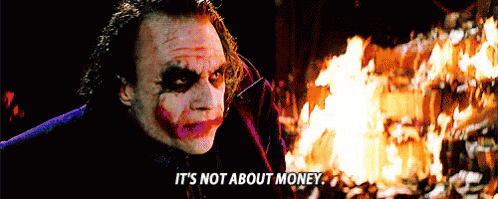 The Joker Says It 'S Not About Money While Standing In Front Of A Fire . GIF