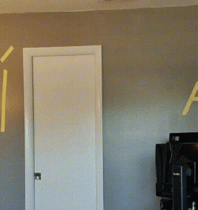 The Letter A Is Painted On The Wall Behind A Door GIF