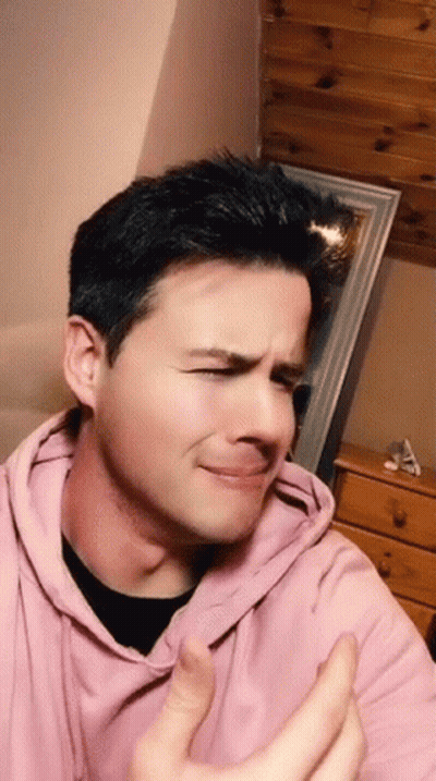 The Man Is Wearing A Pink Hoodie And Making A Funny Face GIF