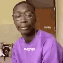 The Man Is Wearing Glasses And A Purple Shirt . GIF