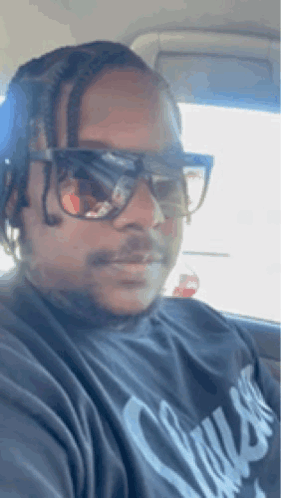 The Man Is Wearing Sunglasses And A Black Shirt . GIF