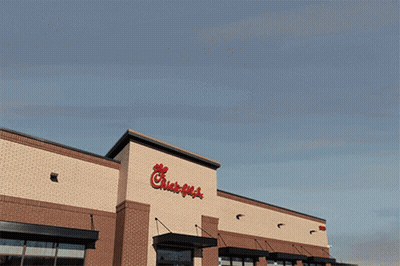 The Outside Of A Chick-Fil-A Restaurant With A Blue Sky Behind It GIF