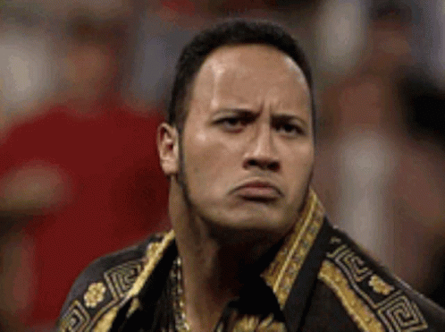 The Rock Is Making A Funny Face While Wearing A Gold And Black Jacket . GIF