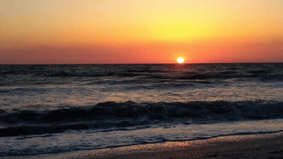 The Sun Is Setting Over The Ocean And The Waves Are Breaking On The Beach GIF