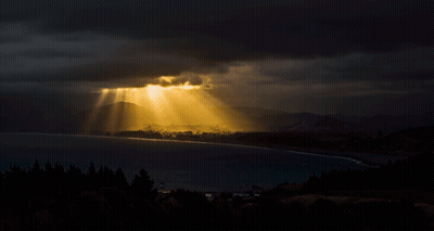 The Sun Is Shining Through The Clouds Over A Lake GIF
