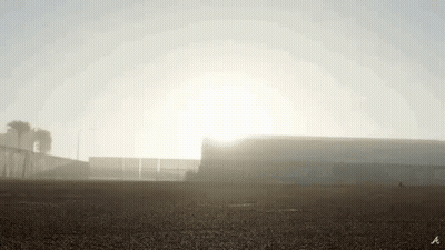 The Sun Is Shining Through The Fog Over A Stadium . GIF