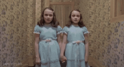 The Twins Are Holding Hands In A Hallway In The Shining Movie . GIF