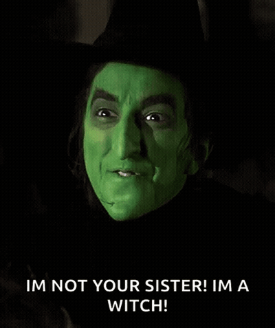 The Wicked Witch From The Wizard Of Oz Is Wearing A Black Hat And Green Makeup . GIF