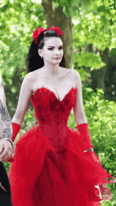 The Woman Is Wearing A Red Dress And Red Gloves . GIF