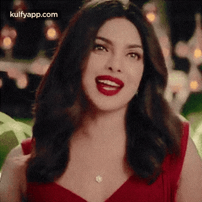 The Woman Is Wearing A Red Dress And Red Lipstick And Smiling . GIF
