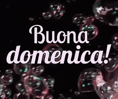 The Word Buona Domenica Is Surrounded By Soap Bubbles On A Black Background . GIF