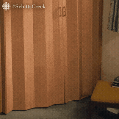 The Word Schitts Creek That Is On A Wooden Door GIF