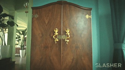 The Word Slasher Is On A Green Wall Next To A Wooden Cabinet GIF