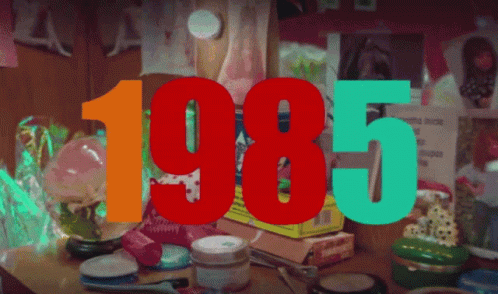 The Year 1985 Is Displayed On A Table Full Of Cosmetics GIF